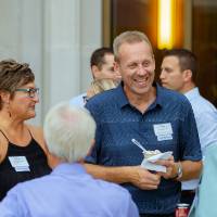 A group of people talking with each other outside.